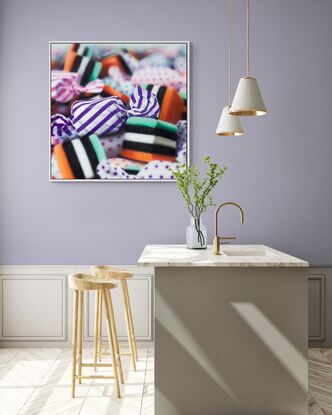 An orange and purple stripped  candy in a pile of multi coloured candies enlarges 1000 times real size. Dynamic photorealism artistry at its finest as it looks so real and pops off the wall

When one views closely, you can see how blur and rougher brush strokes come together for the illusion of realism.