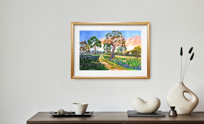 
Riverina Bushwalk is a delightful natural serene landscape painting, featuring a path leading into the distance, with colourful flowers in both cool and warm shades, Australian gum trees scattered around the landscape under a lively warm coral and blue sky.