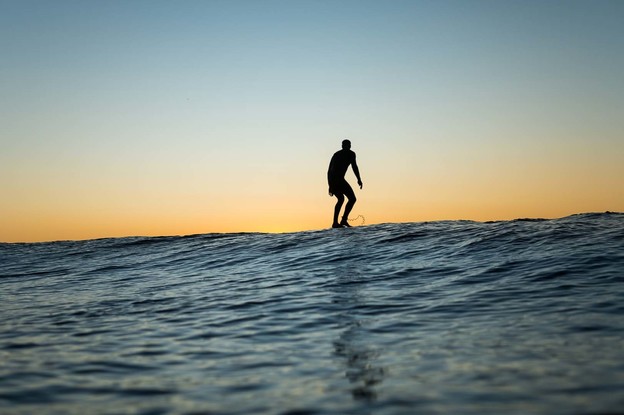 Foil board surfer at sunrise