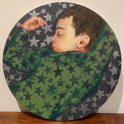 A portrait of a boy sleeping wearing green star pajamas.