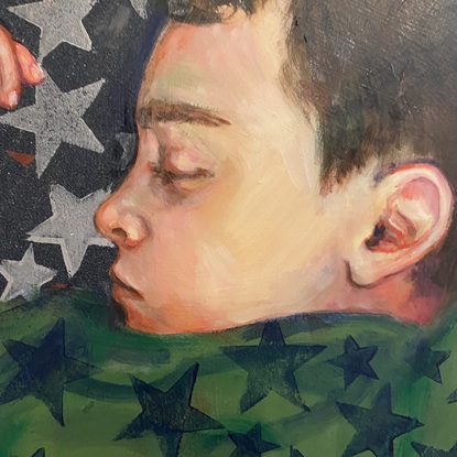 A portrait of a boy sleeping wearing green star pajamas.