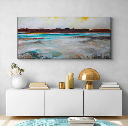 Abstract seascape in spring tones of yellow, blue  and teal with mountain range in the horizon under a dramatic cloudy sky.