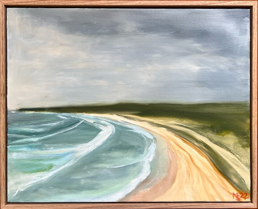 An elevated view of surf, sand, and green headland under a stormy sky