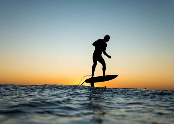 Foil board rider at sunrise