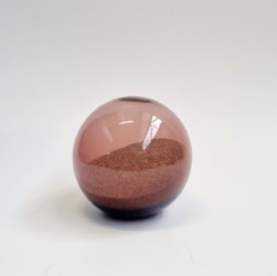 A blown glass ochre sphere holding a memento of the golden sand of the Australian beach