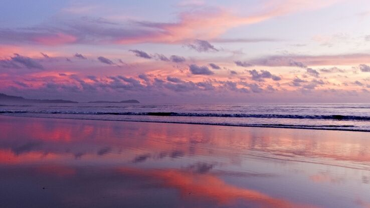 Immerse yourself in the breathtaking beauty of a serene Thai beach at sunset. This captivating photograph captures the essence of tranquility as the sun has dipped below the horizon, painting the sky and its reflections in delicate shades of pink.

The centerpiece of this scene is undoubtedly the mesmerizing sky, gracefully transitioning from soft pastel hues higher up to deeper, more vibrant tones lower down. A few wispy clouds add an ethereal touch. These clouds only enhance the overall sense of peace and serenity, as if they're softly embracing the sun's departure.

The most enchanting aspect of this photo is the reflection in the calm waters below. The sea acts as a mirror, faithfully reproducing the rosy tones of the sky. The water's surface is so still that it almost seems like nature itself is holding its breath, allowing you to soak in the tranquility of this moment.

It's a scene that invites you to pause, find solace in the simplicity of nature's beauty, and reflect on the serenity that can be found in the world around us. Whether you've experienced such a sunset in person or not, this photograph captures the essence of calm, making it a perfect addition to your visual journey.