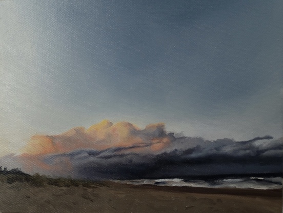 Small oil painting of the beach, with brooding clouds in the distance. 