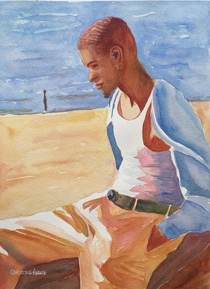 Man sits by the beach.