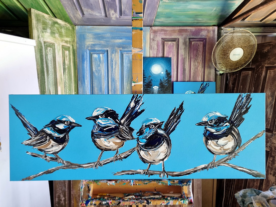 four fairt wrens painted in texture on a bright blue background