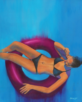 Young woman floating on a rubber ring