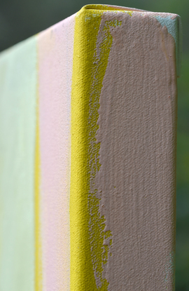 Large swelling peony buds on a pink and yellow striped background.