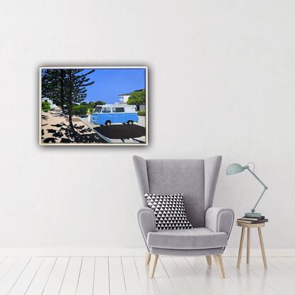 Blue Kombi van in carpark near large trees, both casting strong shadows in the foreground with hint of ocean in the background under and clear blue sky. 