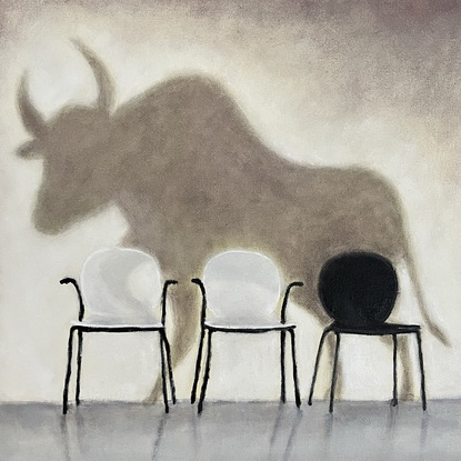 A large bull is projected onto a blank wall with three chairs against the wall. One chair is black, and two chairs are white.