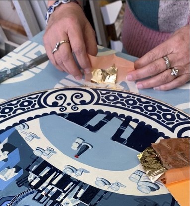 A Chinese restaurant interior depicted on a blue and white china plate set on a blue and white patterned wallpaper.