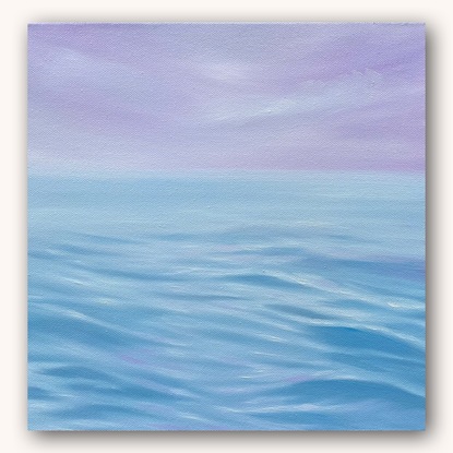 Blue ripples on ocean surface under purple sky