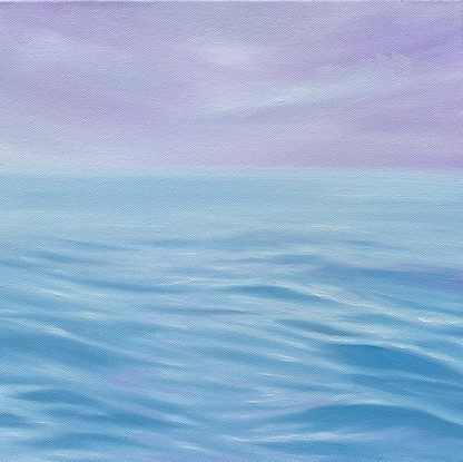 Blue ripples on ocean surface under purple sky