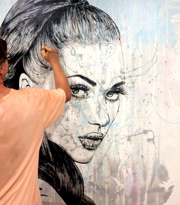 A large canvas painting using acrylics.  An abstract splash of colours on white/cream is the backdrop for the simple sketch (in black)  the face of a beautiful woman with intense eyes that follow you around the room.  She has a long braid of dark hair that feames her face.  The artist has skillfully sketched every hair.  
On the bare shoulder to the woman is a tattoo - the symbol for luck!

It is the type of painting that can fit any room and will have impact while the subtle colours accenting the design and decor of the room.