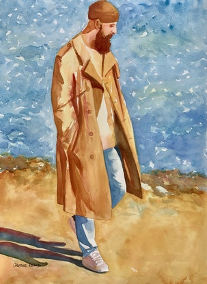 Man walks on the beach wearing a raincoat and beanie.