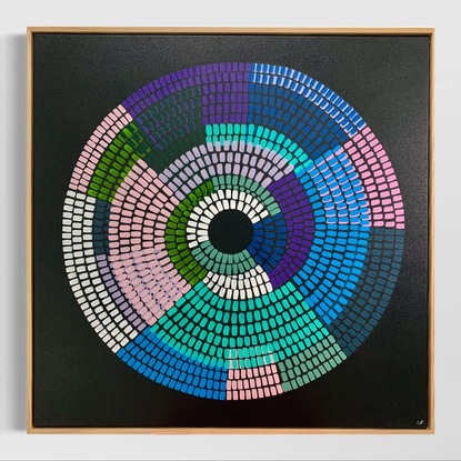 Circular shape made up of bright vibrant strokes, blues pinks purples on a black background. 