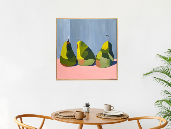 3 green pears in triangle formation on a pink surface before a grey wall.