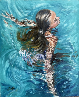 Tanned long haired woman swimming in deep blue water as it flies around and over her