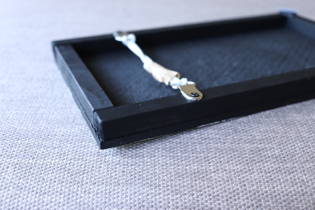 A pepper cracker on a white cloth with an olive background