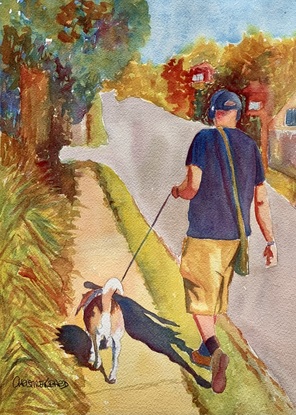 Man walks his dog in the sunshine.