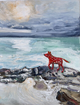 A red spotty dog enjoys  the wind as she explores the sea rocks