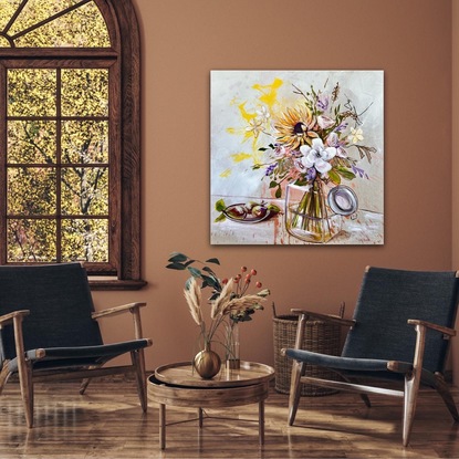 Glass vase filled with flowers and foliage sits beside 3 pears on a plate.