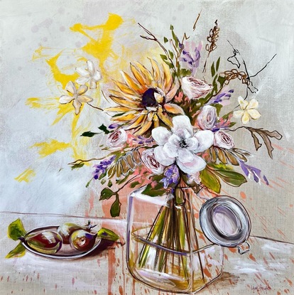 Glass vase filled with flowers and foliage sits beside 3 pears on a plate.