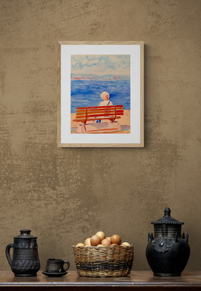 Women sits on a bench by the beach in the sunshine.