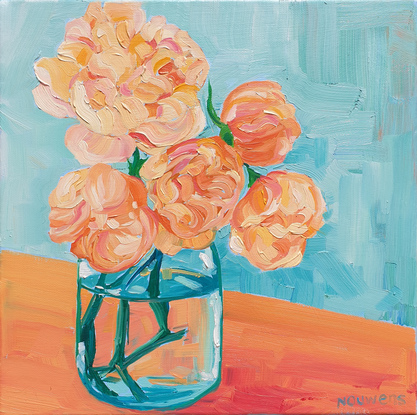 Apricot roses in a vase on a bench.