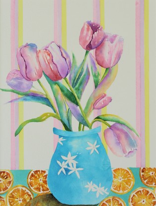 Vibrant pink and purple tulips, in a blue vase sitting on a table, with a citrus tablecloth.