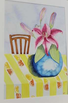 Vibrant pink lilies blooming, in a bright blue vase, contrasting the beautiful yellow citrus table cloth. The subtle blue and purple hues allow the lilies to be the main focus of the artwork.