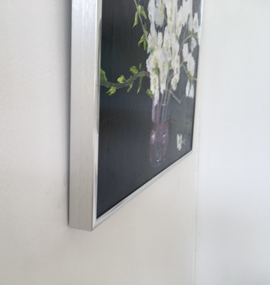 The painting’s dark background shows off the blossoms. The single stem on the table is a horizontal touch to offset the vertical flower stems.