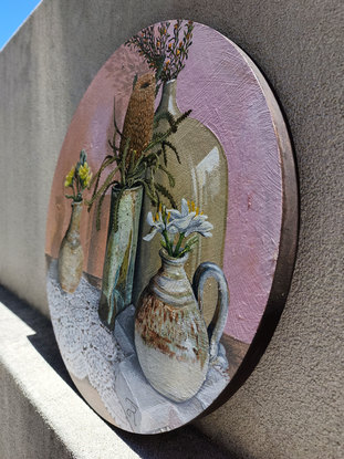 Four vases with flowers sitting on lace. 