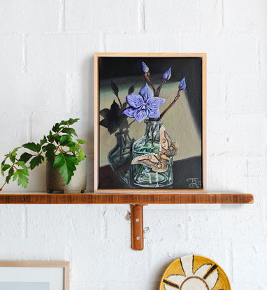 Flower in a glass vase with a moth.