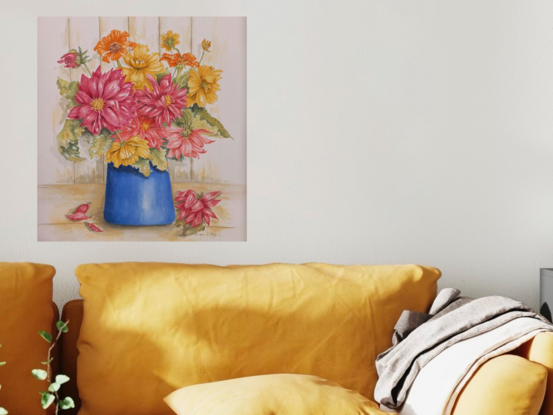 Red, orange and yellow spring flowers with green and brown tinted foliage in a blue vase