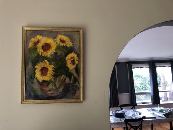 this painting shows bright yellow sunflowers and leaves in a vase