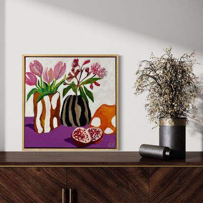 Flowers in the  candy Glass vase and pomegranate on table 