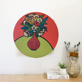 A well balanced painting with white and yellow flowers . A  unique bespoke painting with an orange and green background. The orange vase is stencilled with black flowers.  This painting is circular and will suit any room in the house. 