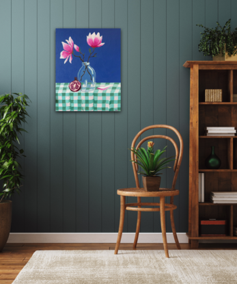 A still life depicting - a glass vase with two magnolia flowers and buds, a pomegranate leaning against the vase and a single fallen petal sitting nestled into the gingham creased table cloth. With a bold pacific blue backdrop 