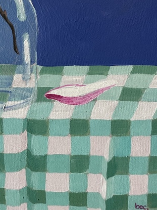 A still life depicting - a glass vase with two magnolia flowers and buds, a pomegranate leaning against the vase and a single fallen petal sitting nestled into the gingham creased table cloth. With a bold pacific blue backdrop 