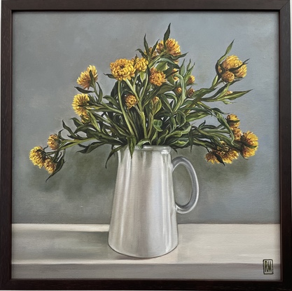 A square canvas frames a large bunch of yellow straw flowers nestled in a white pottery jug.  There are many intertwining leaves and stems.  Light comes from the right hand side casting shadows on the wall and mantle where the jug sits and turning the light grey wall bluish green.