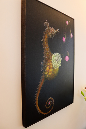 a composition of marble snails, a giving birth seahorse, and a flower in a dark environment.