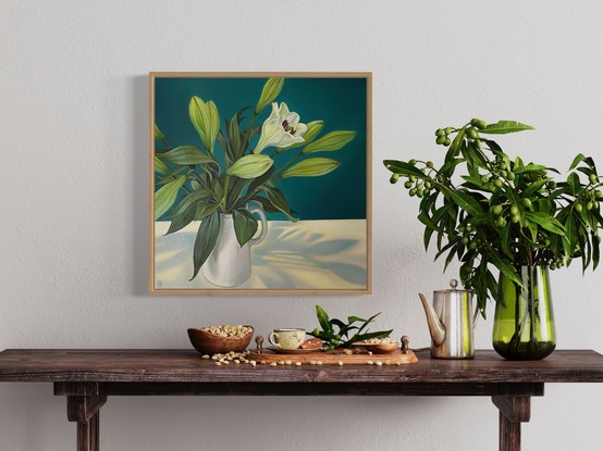 A square canvas frames a large bunch of white lilies which sit in a white jug on a white table.  Lit from above, bluish shadows fan out on the table below.  The background is painted in a strong peacock blue.