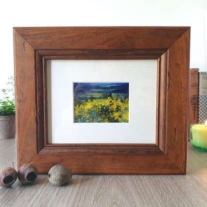 Miniature landscape of dark blue fields and hills with yellow wattle bushes, by Australian artist Victoria Collins