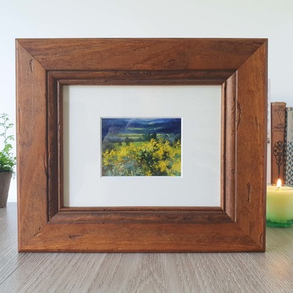 Miniature landscape of dark blue fields and hills with yellow wattle bushes, by Australian artist Victoria Collins