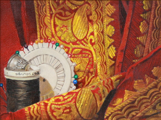 A thimble sits atop a spool of black thread against which rests a circular holder of dressmaker's pins. The articles are entwined with red and gold silk.