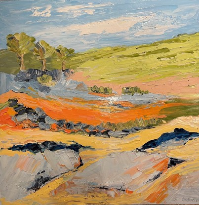 A creek runs through this painting surrounded by rocks, gum trees, green hills and a blue sky.